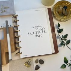 an open notebook sitting on top of a table next to other office supplies and decorations