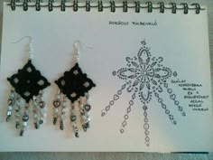 two black and white earrings on top of a piece of paper