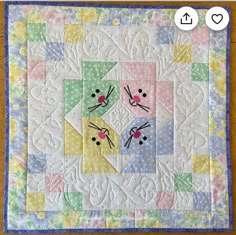 a quilted wall hanging with two birds on it