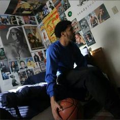 a man sitting on top of a bed next to a basketball