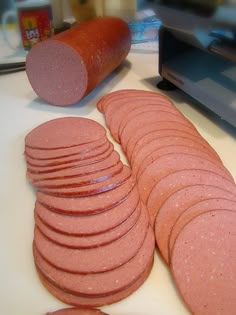 a pile of hot dogs next to a bunch of sausages on a cutting board