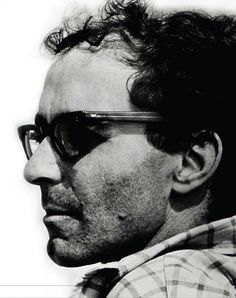 black and white photograph of a man with glasses looking off to the side in front of him