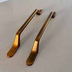 two shiny gold handles on a white counter top with no one in it or someone else