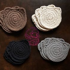 four crocheted coasters sitting on top of a table