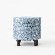 an upholstered stool with wooden legs and a blue patterned cover on it, against a white background