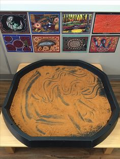 a cake pan with some food in it sitting on a wooden table next to pictures