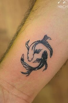 a tattoo on the wrist of a man with a koi fish in it's hand