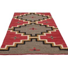 a red and brown rug with an intricate design on the bottom, in front of a white background