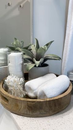 a wooden tray with white towels and other items