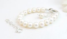 "A classic real freshwater pearl bracelet for newborn, infant, baby, child, or little girl. This bracelet is for her to wear now AND later! It is created with Grade-A 5.5mm round freshwater pearls, a sterling silver heart shaped lobster clasp with an attached 1\" \"Grow with Me\" extender chain, as well as a separate 1.25\" sterling silver chain to attach when she is older. This is a wonderful \"Baby to Bride\" keepsake gift. The pearls are strung on super strong, stainless-steel wire for extra Real Pearl Bracelet, Bride Bracelet, White Pearl Jewelry, Baby Pearls, Initial Earrings, Baby Bracelet, Baptism Girl, Freshwater Pearl Bracelet, Real Pearls