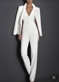 a woman in white suit and heels posing for the camera with her hands on her hips