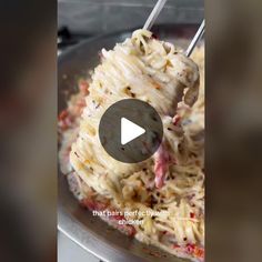 a bowl filled with pasta and meat on top of a table next to a video player