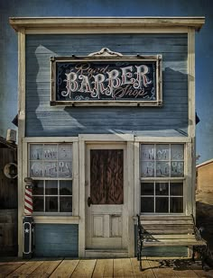 the barber shop is painted blue and has an old fashioned bench in front of it