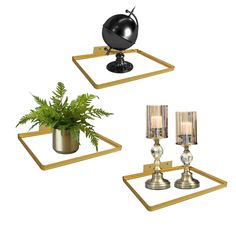 three metal candlesticks and a potted plant on top of gold trays