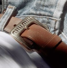 a belt with the word gucci on it sitting in someone's jeans pocket