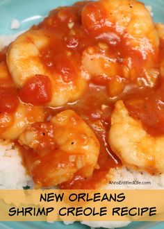 a blue plate topped with shrimp and rice covered in sauce on top of white rice