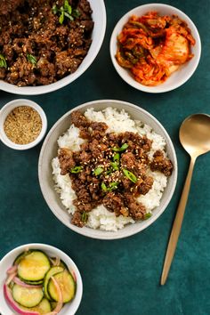 three bowls filled with rice, meat and vegetables next to spoons on a table