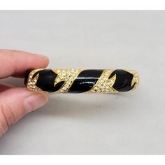 Late 1990s goldtone black enamel with pavé round clear rhinestones "flames" on one side and bumpy goldtone "flames" on the other side reversable night & day cuff bracelet with box clasp. Marked "Napier©" in script. Measures: 1/2 inch tall by 2 6/8 inches wide and 2 5/16 inches deep. Interior circumference is about 6 1/2 inches. Excellent condition. An identical bracelet is shown on pg. 711 of Melinda L. Lewis & Henry Swen's book "The Napier Co.: Defining 20th Century American Costume Jewelry." American Costume, Night Day, Box Clasp, Day For Night, Clear Rhinestones, Black Enamel, The Other Side, Vintage Signs, Cuff Bracelet