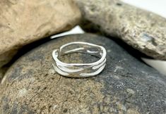 A minimalist 925 Sterling Silver (hallmarked) ring, featuring a unique, wave design in an adjustable sizeThis ring is perfect for those who are after something elegant and timeless!Perfect for stacking, or wearing aloneMaterial: 925 Sterling SilverWeight: 1.7 gramsWidth: 0.5 cmSize: AdjustableAdjustable size range: UK M/US 6 - UK S/US 9Comes wrapped ready for gifting! Silver Band Rings, Plant Rings, Multi Band Ring, Hippie Rings, Thick Ring, Zierlicher Ring, Wave Ring, Chunky Rings, Ring Minimalist