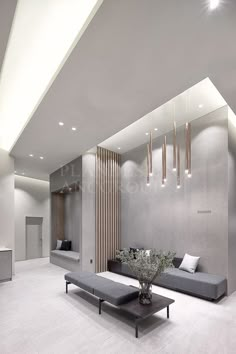 a modern living room with grey couches and white tile flooring, along with hanging lights