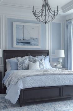 a bedroom with a bed, chandelier and pictures on the wall above it