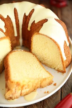 a bundt cake with white icing and slices cut from it on a plate