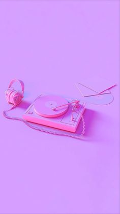 a turntable and headphones on a purple background with pink paper in the shape of a record player