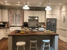 a kitchen with two stools at the island