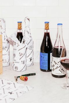 several bottles of wine are sitting on the counter next to some paper towels and corkscrews