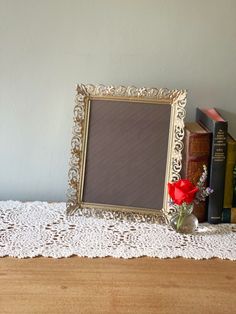 a table topped with books and a framed photo next to a vase filled with flowers