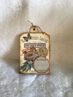 an old fashioned tag with flowers on it