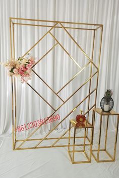 two tables with vases and flowers on them in front of a white curtained backdrop