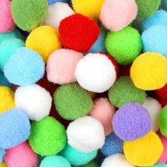 multicolored pom - poms are scattered on top of each other