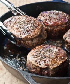 hamburger patties being cooked in a skillet