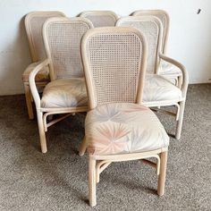 four cane back chairs with floral upholstered cushions