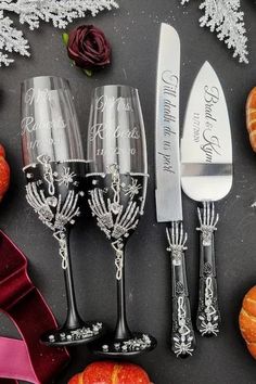 two wine glasses and a knife are sitting next to some pumpkins on the table