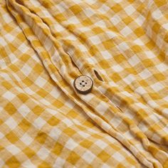 a button on a yellow and white checkered shirt