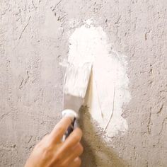 a person using a paint roller on a wall