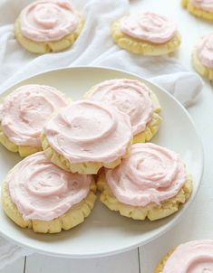 a white plate topped with cookies covered in pink frosting