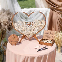 a heart shaped wooden sign sitting on top of a table next to other items and flowers