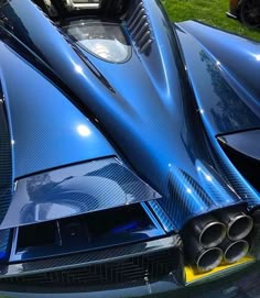 a blue sports car parked on top of a lush green field