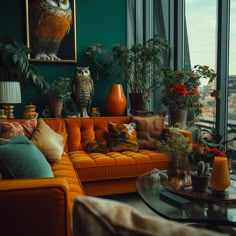 an orange couch sitting in front of a window filled with potted plants and owls