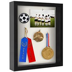 a framed display with medals and other sports memorabilia on it's side, including a soccer ball