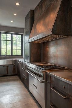 a large kitchen with stainless steel appliances and cabinets in the center, along with an island