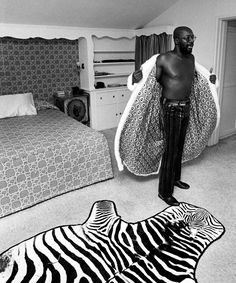 a man standing next to a zebra rug in a bedroom