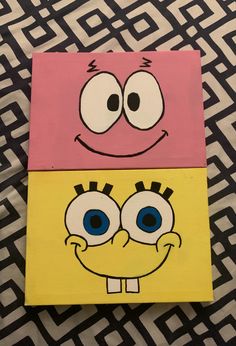 two square paintings with faces painted on them, one is yellow and the other is pink