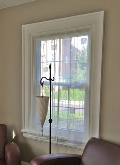 a living room with two chairs and an umbrella in the window sill on the wall