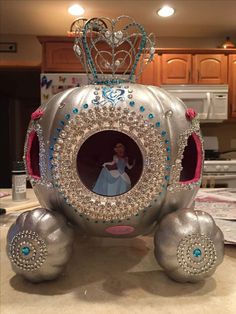 a silver carriage with a princess on it's face in the middle of a kitchen