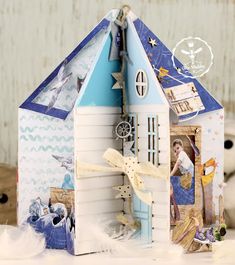 a paper doll house with pictures on the front and sides, sitting on a table