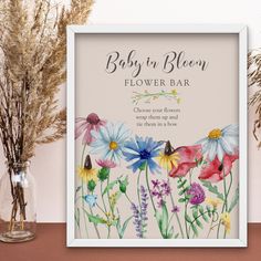 a baby in bloom flower bar sign next to flowers